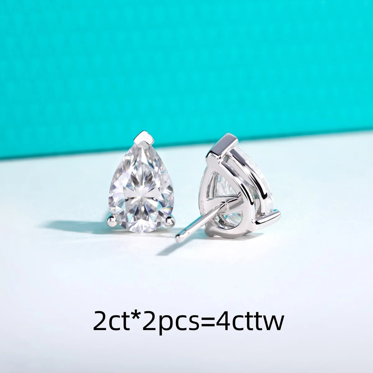 Pair of pear-shaped diamond earrings on a light blue background