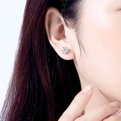 Close-up of an ear wearing a diamond stud earring with a blurred background