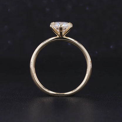 Gold ring with a diamond on a dark background