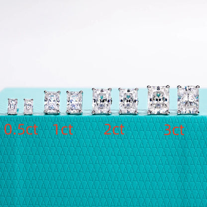 Diamond earrings displayed on a teal mat with weight labels.
