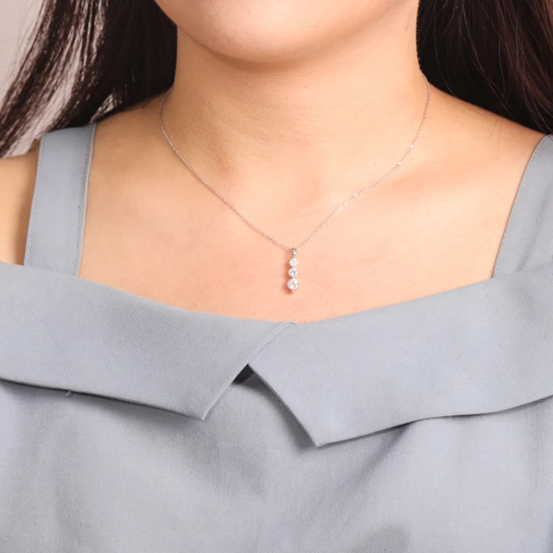 Necklace with a pendant worn by a person in a gray top