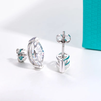 Silver earrings with large clear gemstones on a light gray background