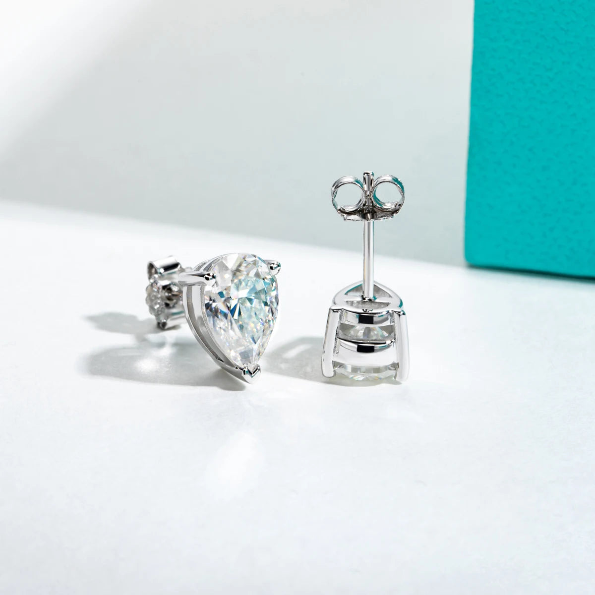 Pair of silver earrings with clear gemstones on a light background
