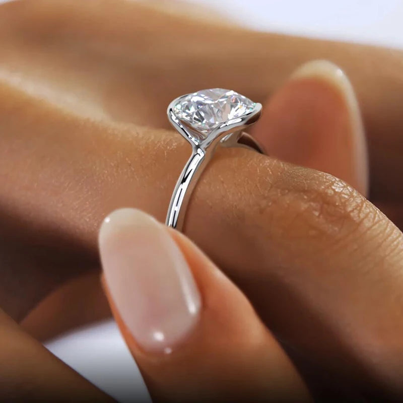 Close-up of a diamond ring on a finger with a blurred background