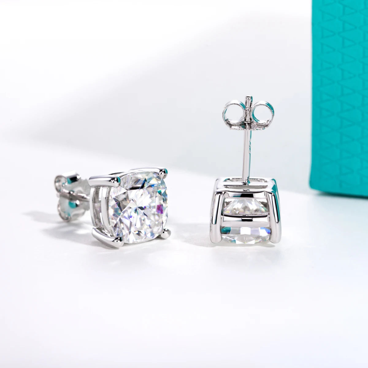 Silver stud earrings with clear gemstones on a white surface.
