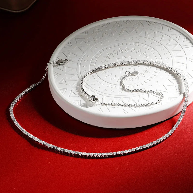 Silver chain necklace on a white circular stand with a red background