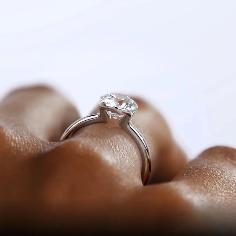 Diamond ring on a finger with a blurred background