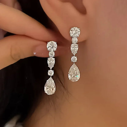 Elegant silver teardrop earrings worn by a person