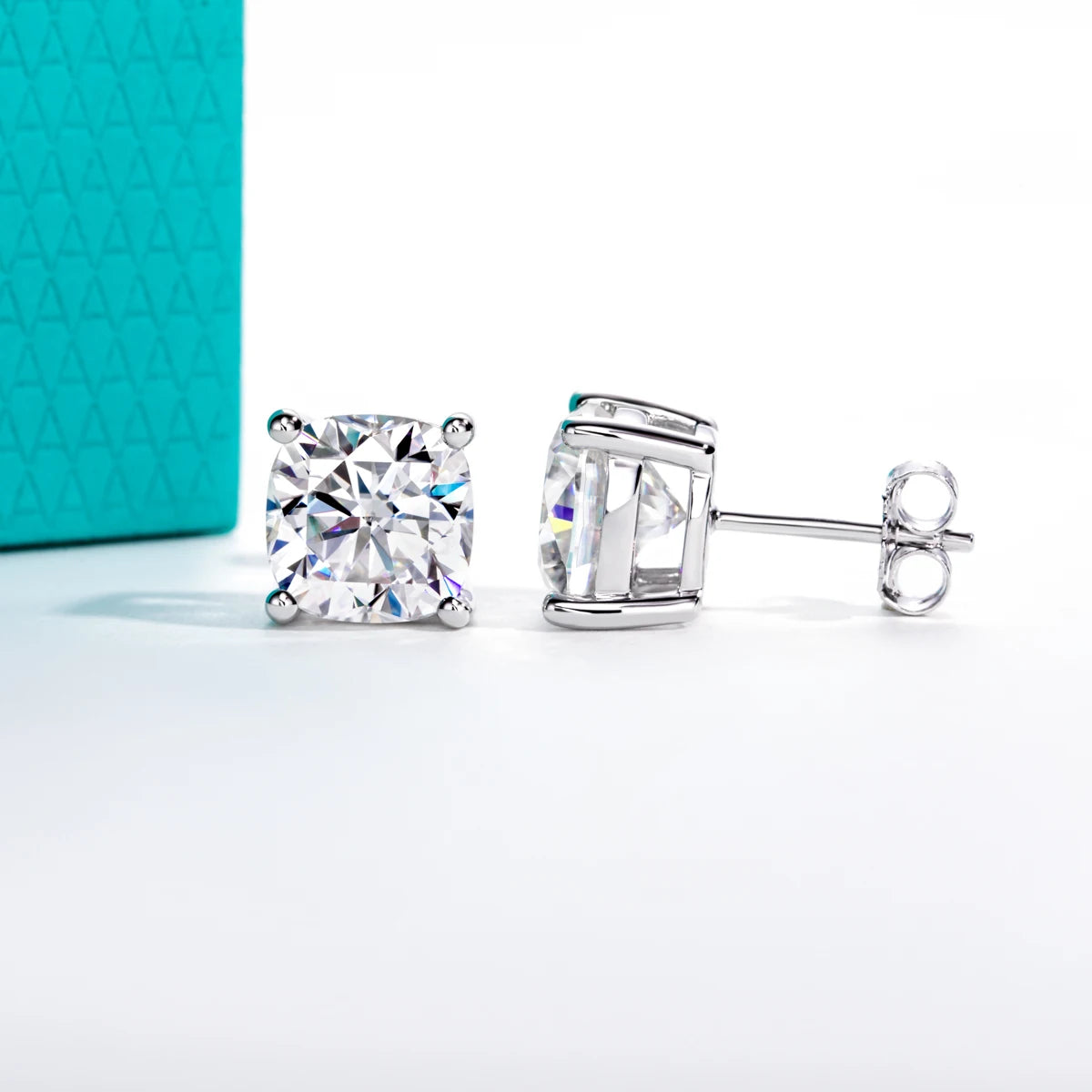 Pair of silver stud earrings with clear gemstones on a light gray background