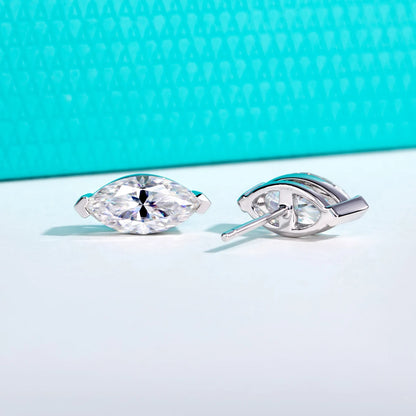 Silver earrings with clear gemstones on a light blue background
