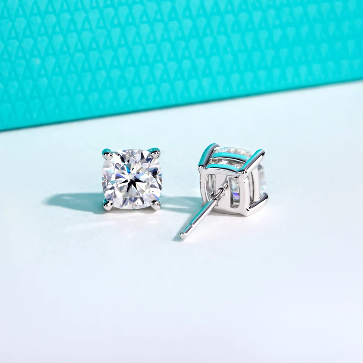 Square-cut stud earrings on a light blue background