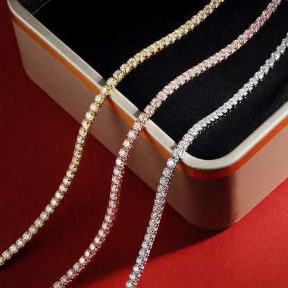 Three diamond necklaces in gold, rose gold, and silver on a red surface with a black box.