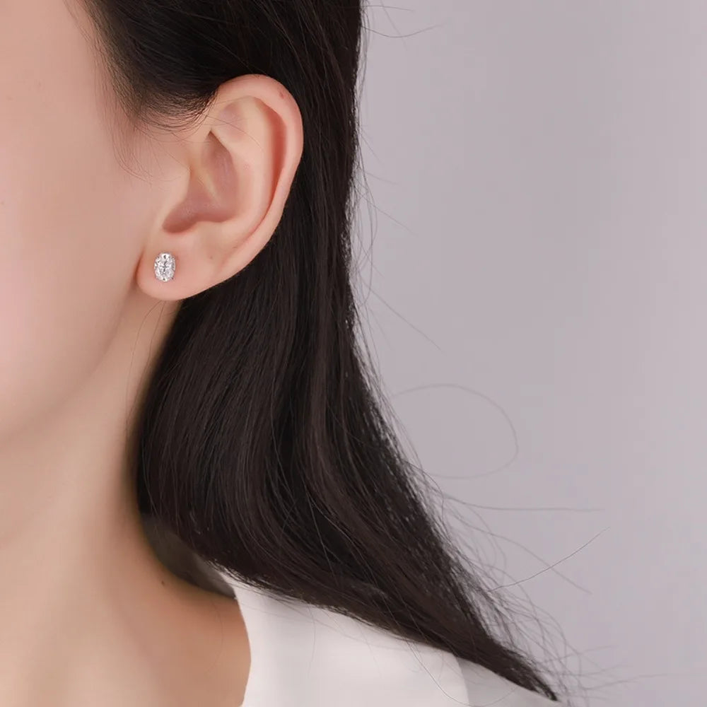 Close-up of an ear wearing a diamond earring with a blurred background