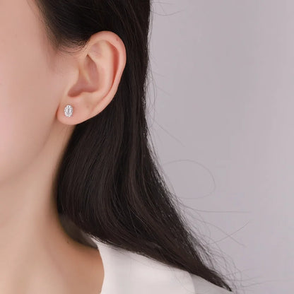 Close-up of an ear wearing a diamond earring with a blurred background