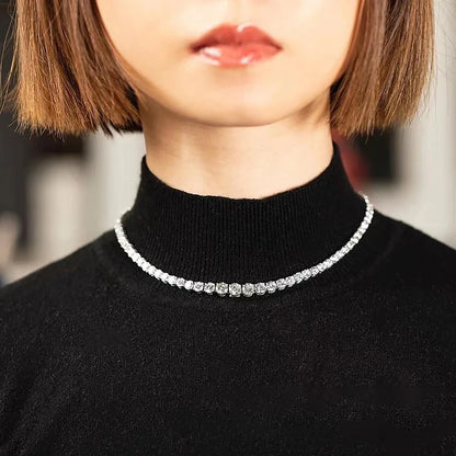 Person wearing a black turtleneck with a diamond necklace