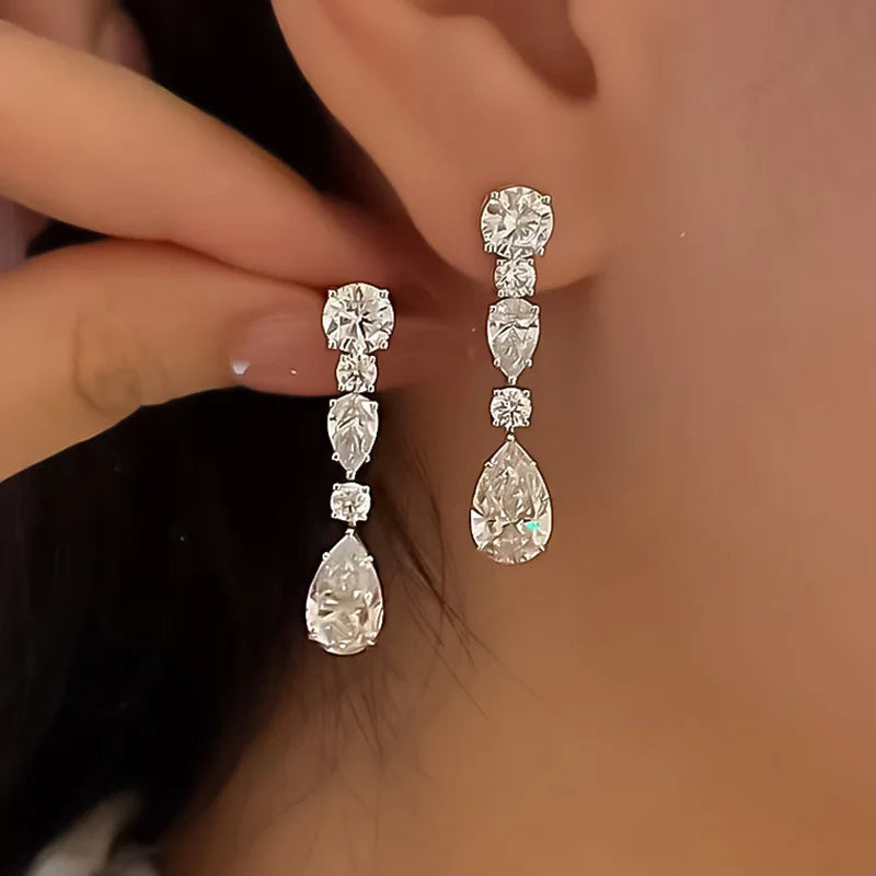 Elegant diamond earrings being worn, with a blurred background to focus attention on the jewelry.