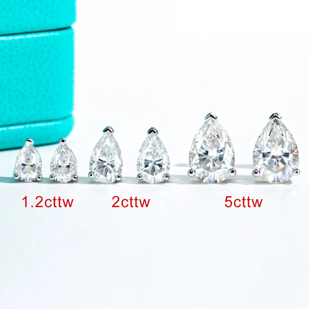 Teardrop-shaped diamonds of different carat weights on a white background with turquoise box.