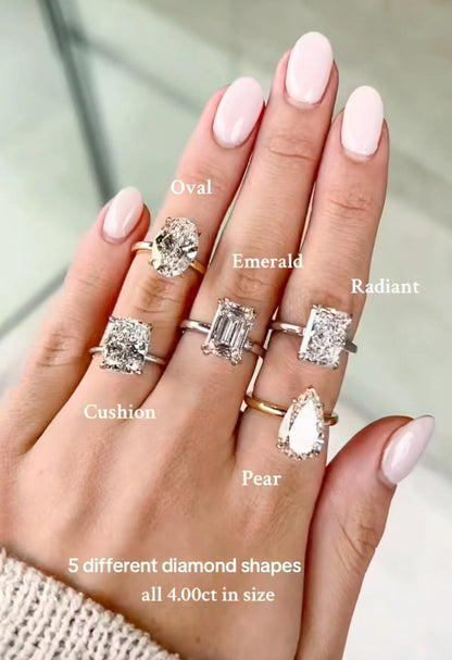 Hand wearing five diamond rings with labeled diamond shapes on a neutral background