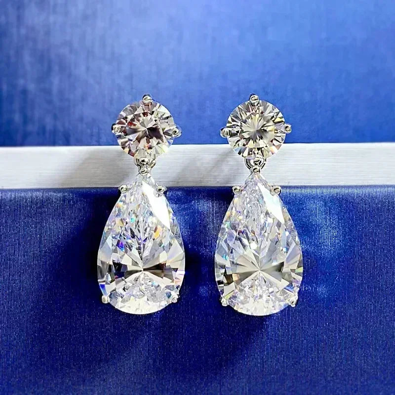 Pair of teardrop-shaped diamond earrings on a blue background