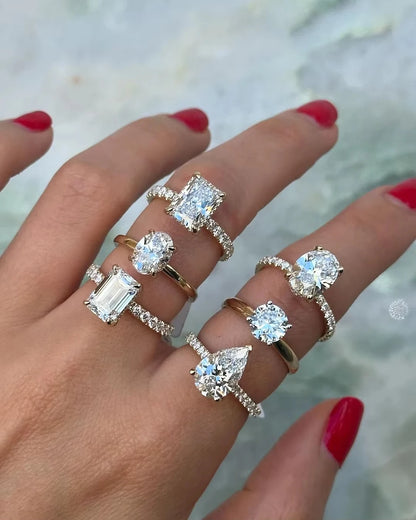 Hand wearing multiple diamond rings with a blurred background
