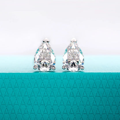 Pair of teardrop-shaped crystal earrings on a teal background with a geometric pattern.