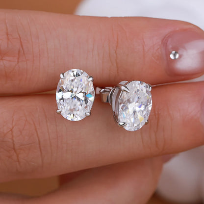 Diamond stud earrings on a person's finger
