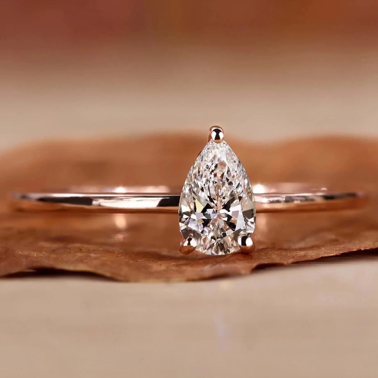 Diamond ring with a pear-shaped gemstone on a wooden surface