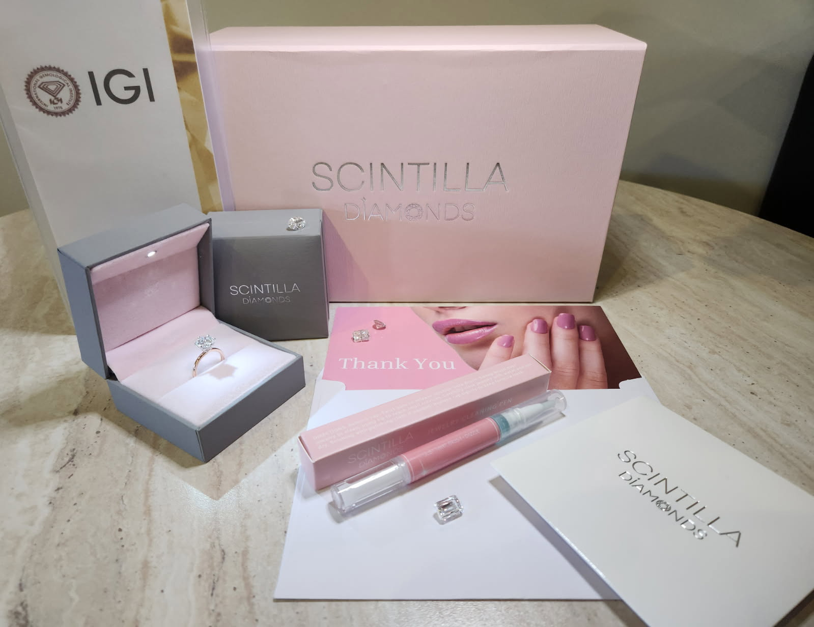 Scintilla diamond jewelry set with packaging on a wooden surface